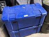 une boîte bleue posée par terre à côté d'une poubelle