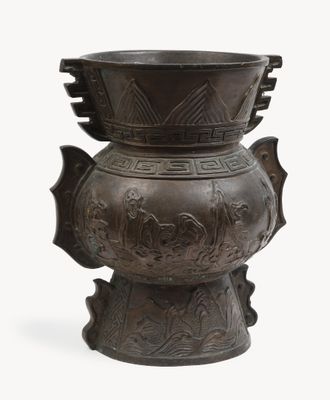 a large metal vase with a bird design on it