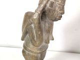 statue of a woman in a kneeling position on a white surface