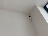 a toilet in the corner of a room with a window