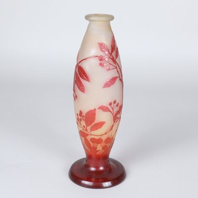 un vase rouge et blanc posé sur un socle, sur fond blanc