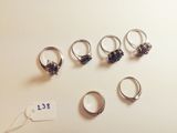 six different rings are arranged on a table with a price tag
