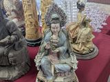many statues on a red table with a red table cloth