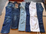 Plusieurs paires de jeans sont disposées sur une boîte en carton