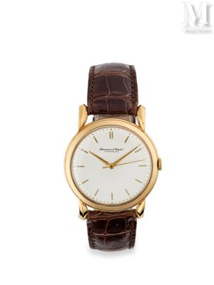 une montre-bracelet en or avec un cadran blanc et un bracelet en cuir marron