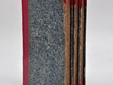 three books that are lined up on a white surface
