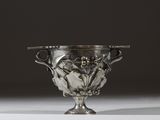 un vase ancien en argent orné de fleurs et de feuilles sur un fond blanc