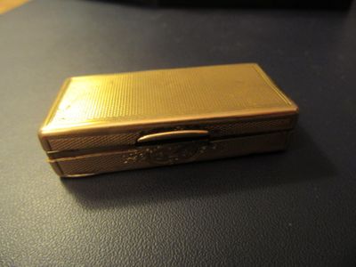 a small gold cigarette case sitting on a table