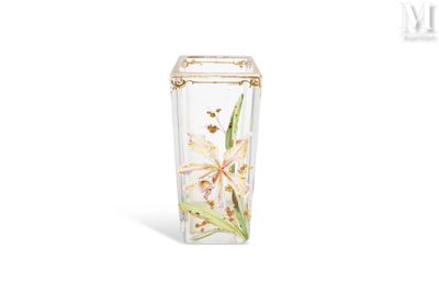 un vase contenant une fleur, posé sur une surface blanche