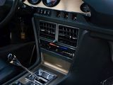 a car dashboard with a steering control and a clock