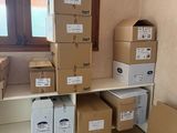 des cartons sont empilés sur une étagère dans une pièce dotée d'une fenêtre