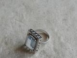 a silver ring with a stone in it on a table