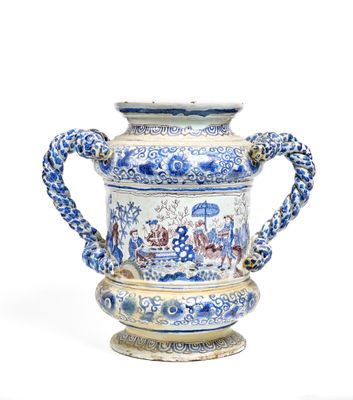 a blue and white vase with a handle on a stand