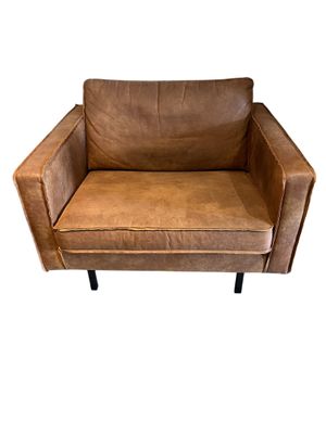 fauteuil en cuir marron avec des pieds en métal noir sur fond blanc