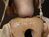 a doll that has a doughnut in it ' s mouth