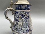 a blue and white vase with a statue on it