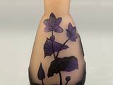 a vase with purple flowers on it sitting on a table