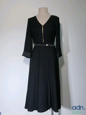 une robe noire sur un mannequin sur fond blanc
