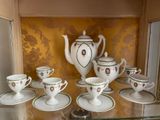 a display case with a tea set and cups and saucers