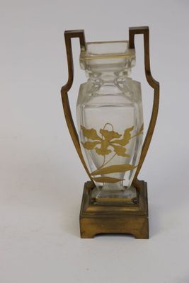 un vase en verre posé sur un socle en bois, lui-même posé sur une surface blanche
