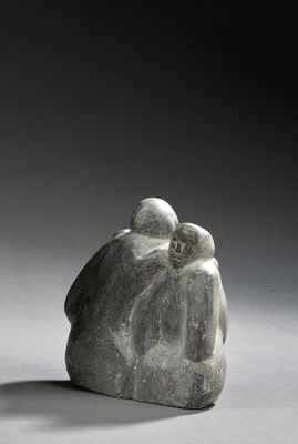 sculpture of a couple sitting on a rock on a gray surface