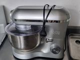 a silver mixer sitting on a kitchen counter next to a pan
