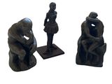 trois figurines représentant un homme et une femme assis sur un banc