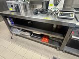 de nombreuses casseroles et poêles posées sur un plan de travail en inox