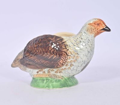 a ceramic bird sitting on top of a green base