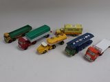 cinq camions miniatures alignés sur une table