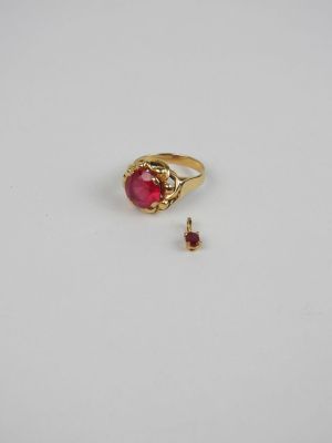 a close up of a ring with a red stone in it