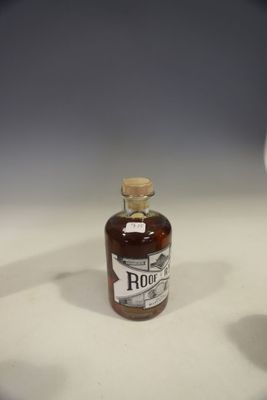 a bottle of rum sitting on a table next to a glass of wine