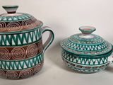 une théière et une cafetière posées l'une à côté de l'autre sur une table
