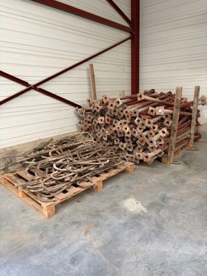 un gros tas de bois dans un entrepôt, avec des palettes au sol