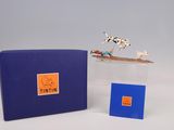 une petite figurine représentant un chien posée sur une boîte