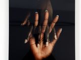 black and white photograph of a woman ' s hands with white nails