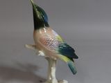 a figurine of a bird sitting on a branch