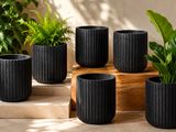 a set of four black planters sitting on top of a wooden table