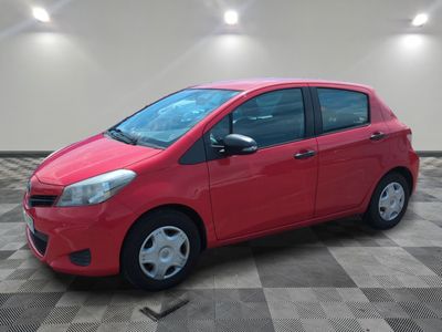 a red car is parked in a room with a checkered floor