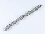 bracelet made of silver colored metal with a design of flowers and leaves