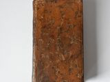 an old book sitting on a white surface with a white background