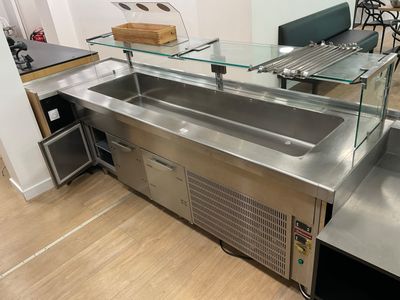 a stainless steel kitchen with a glass counter top