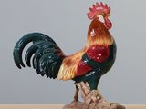 a figurine of a rooster on a wooden table