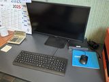 un bureau d'ordinateur sur lequel se trouvent un écran, un clavier et une souris