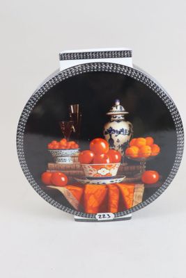 a plate with a picture of a bowl of oranges and a vase on it