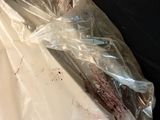 a sandwich wrapped in plastic sitting on a couch