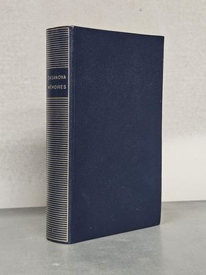 un livre bleu posé sur une table près d'un mur