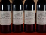 three bottles of red wine are lined up on a red table