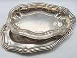 deux assiettes plaquées argent posées sur une table blanche, sur fond blanc