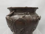 un vase marron orné d'un oiseau, exposé
